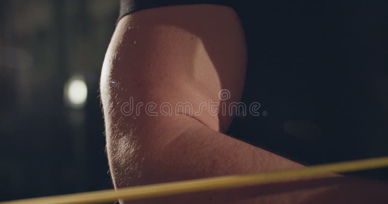 El brazo hinchado del macho cercano durante el bucle de arrastre con la mano en un gimnasio oscuro metrajes