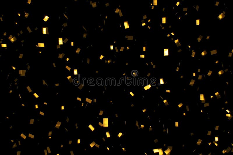 El brillo descendente del oro foil confeti, en fondo negro, día de fiesta y la diversión festiva