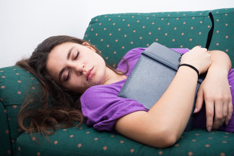 El caer de la muchacha dormido en el sofá en casa fotografía de archivo El caer de la muchacha dormido en el sofá en casa fotografía de archivo
