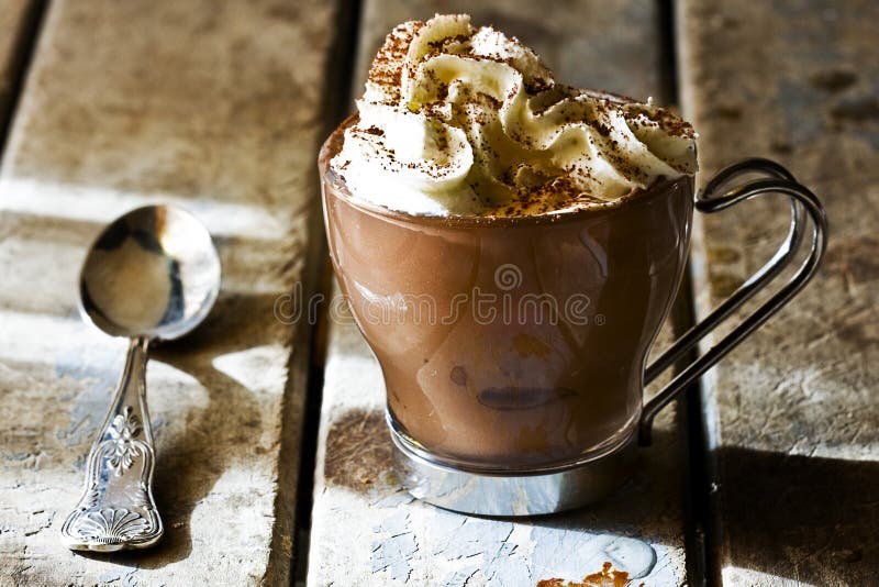 Still life shot of cup of espresso coffee with chocolate and whipped cream on rustic wooden table illuminated by the Sun. Still life shot of cup of espresso coffee with chocolate and whipped cream on rustic wooden table illuminated by the Sun