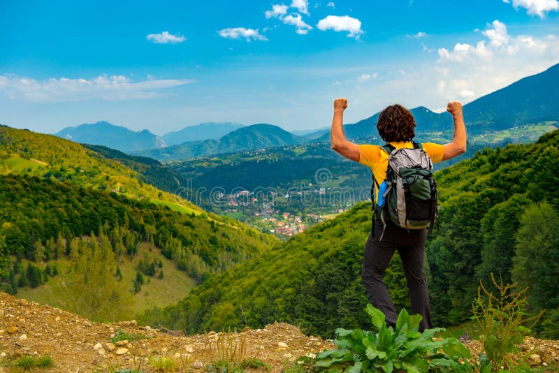 El caminante joven de la montaña con los brazos aumentó para arriba, celebrando y disfrutando de un paisaje hermoso de la montaña foto de archivo libre de regalías El caminante joven de la montaña con los brazos aumentó para arriba, celebrando y disfrutando de un paisaje hermoso de la montaña foto de archivo libre de regalías