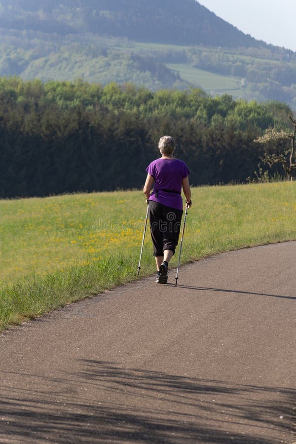 Mujer practicando Nordic Walking en un parque primaveral imágenes de archivo libres de regalías