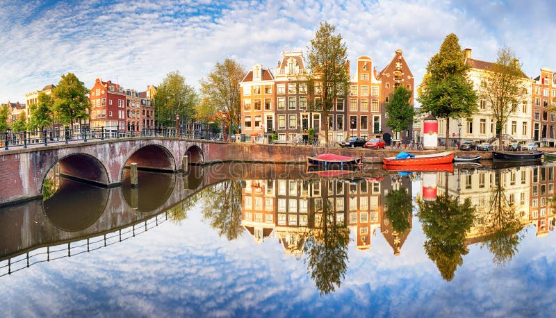 El canal de Amsterdam contiene las reflexiones vibrantes, Países Bajos, panora