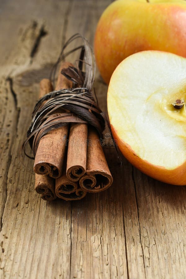 el canela se pega con la manzana en la tabla de madera fotos de archivo el canela se pega con la manzana en la tabla de madera fotos de archivo