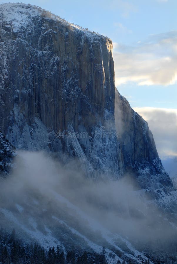 El Capitan illuminated by rising sun on a misty morning