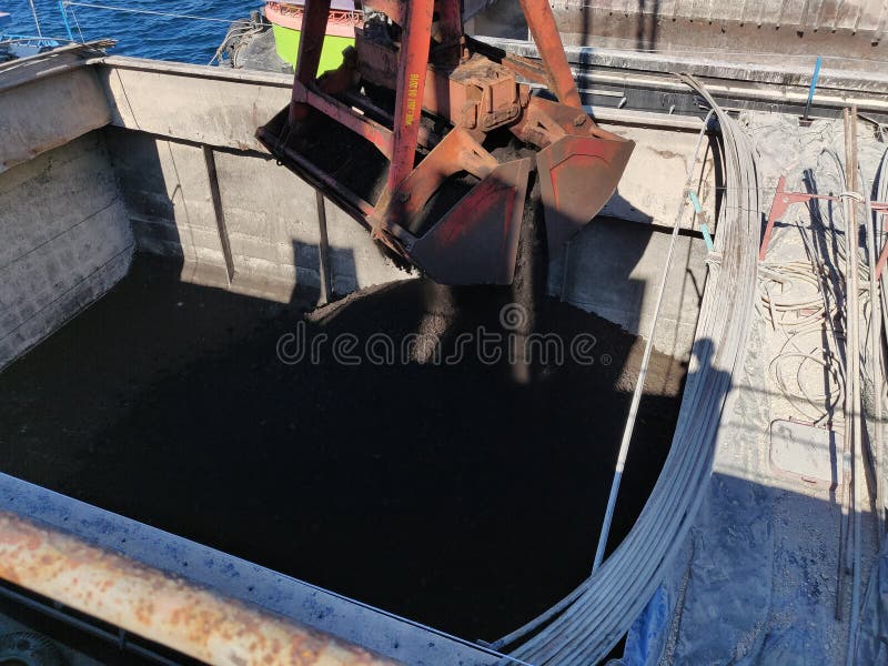 El carbón del lanzamiento del gancho agarrador de la grúa en la gabarra, descargando la operación fotos de archivo libres de regalías El carbón del lanzamiento del gancho agarrador de la grúa en la gabarra, descargando la operación fotos de archivo libres de regalías