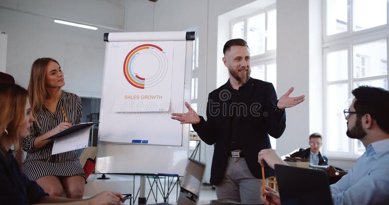 El centro acertado positivo envejeció al hombre de negocios que llevaba el seminario moderno de la oficina, hablando con los empl