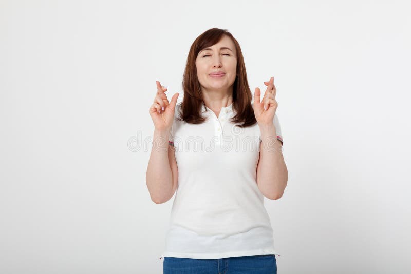 El centro envejeció a la mujer que cruzaba sus fingeres y que deseaba para la buena suerte La camiseta blanca en blanco, imita pa fotos de archivo libres de regalías El centro envejeció a la mujer que cruzaba sus fingeres y que deseaba para la buena suerte La camiseta blanca en blanco, imita pa fotos de archivo libres de regalías