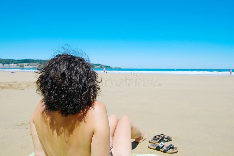 El centro envejeció a la mujer que descansaba en la playa cerca del mar foto de archivo El centro envejeció a la mujer que descansaba en la playa cerca del mar foto de archivo