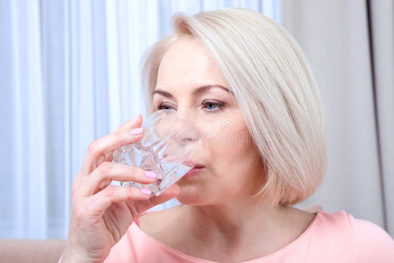 El centro hermoso del retrato envejeció el agua potable de la mujer por la mañana fotografía de archivo libre de regalías El centro hermoso del retrato envejeció el agua potable de la mujer por la mañana fotografía de archivo libre de regalías
