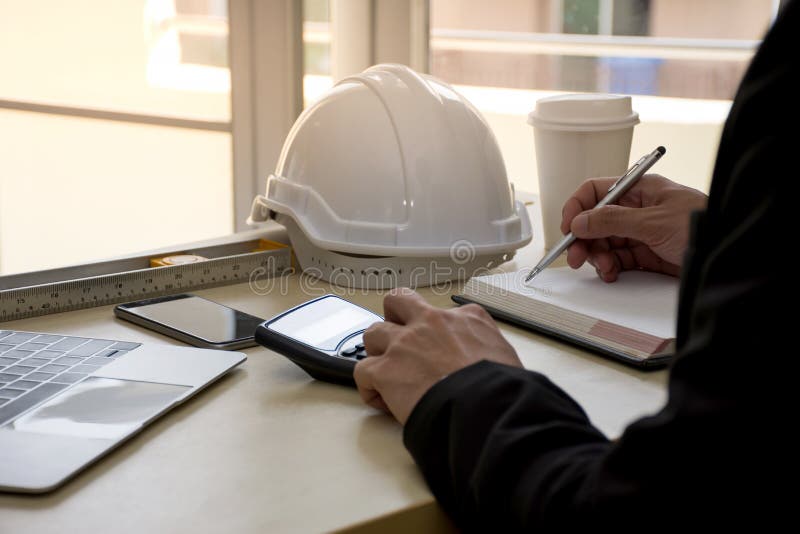El cierre para arriba del ingeniero de diseño civil está haciendo cálculos del análisis estructural usando una calculadora cientí fotografía de archivo El cierre para arriba del ingeniero de diseño civil está haciendo cálculos del análisis estructural usando una calculadora cientí fotografía de archivo