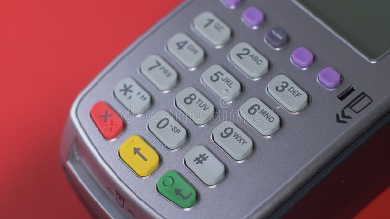 El cliente paga con un teléfono negro a través de un terminal gris que se coloca metrajes