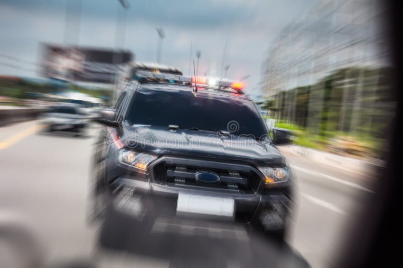 El coche policía enfocó rápidamente para abrir la sirena, conduciendo a lo largo de t fotos de archivo El coche policía enfocó rápidamente para abrir la sirena, conduciendo a lo largo de t fotos de archivo