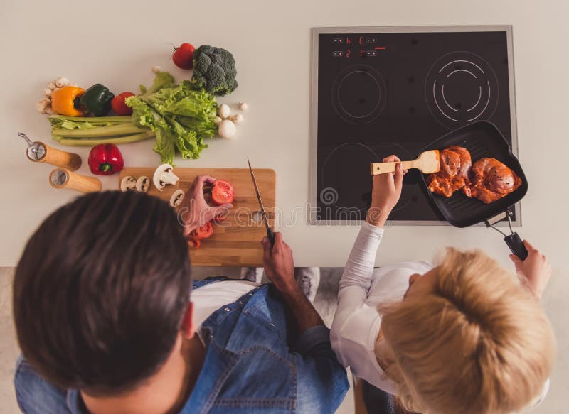 El cocinar hermoso de los pares fotografía de archivo libre de regalías El cocinar hermoso de los pares fotografía de archivo libre de regalías