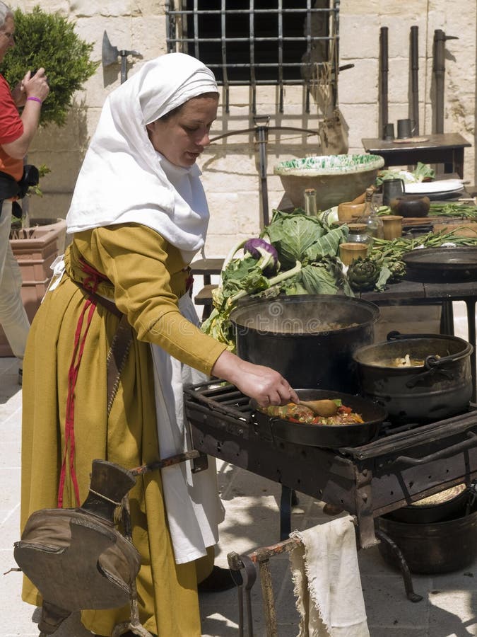 MDINA, MALTA - APR10- Woman preparing traditional food during medieval reenactment in the old city of Mdina in Malta April 10, 2010. MDINA, MALTA - APR10- Woman preparing traditional food during medieval reenactment in the old city of Mdina in Malta April 10, 2010