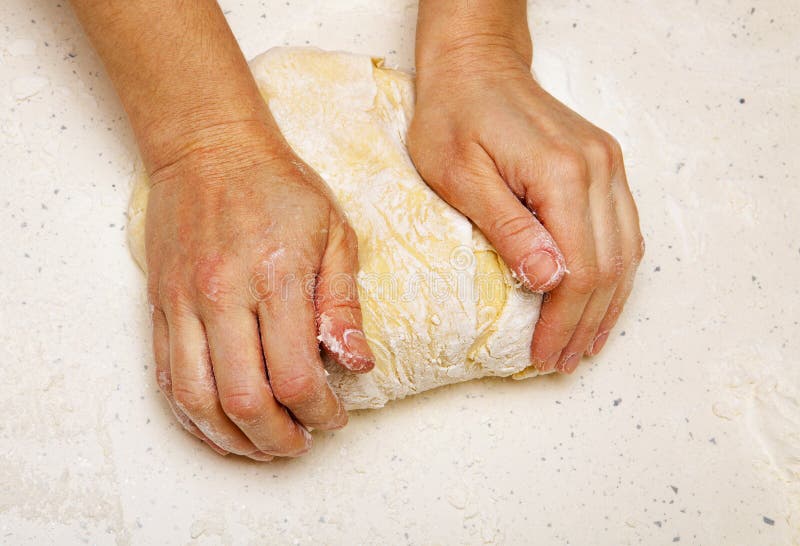 Hands of the cook who kneads dough for bread. Hands of the cook who kneads dough for bread