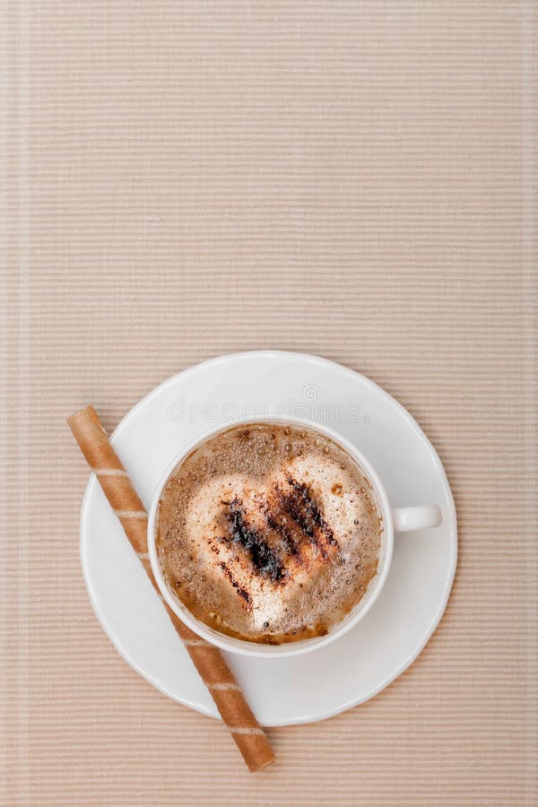El coffe y la galleta blancos de la taza ruedan con crema en fondo marrón fotografía de archivo libre de regalías El coffe y la galleta blancos de la taza ruedan con crema en fondo marrón fotografía de archivo libre de regalías