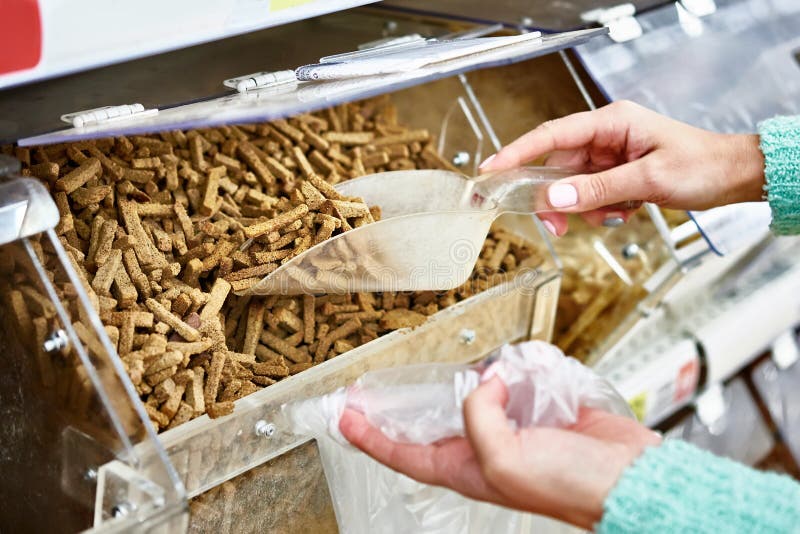El comprador en tienda compra galletas del pan usando la cucharada para los productos fotos de archivo libres de regalías El comprador en tienda compra galletas del pan usando la cucharada para los productos fotos de archivo libres de regalías