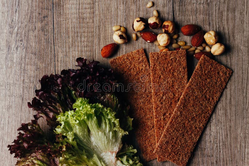 el concepto de nutrición apropiada: frutas secadas, nueces, verdes, mentira en una tabla de madera
