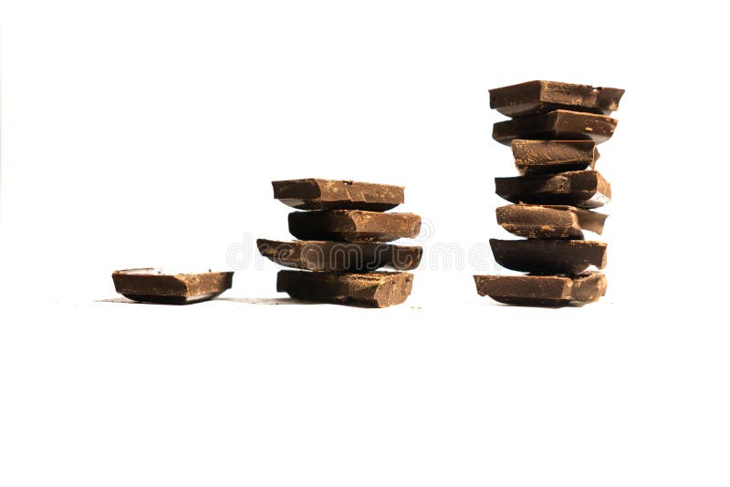 El concepto de un gráfico de beneficio hecho de los cubos del chocolate aislados en el fondo blanco con el espacio de la copia imagen de archivo El concepto de un gráfico de beneficio hecho de los cubos del chocolate aislados en el fondo blanco con el espacio de la copia imagen de archivo
