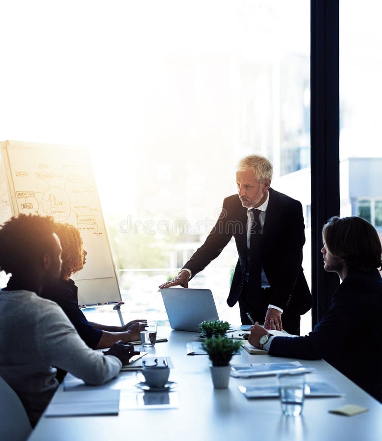 El conduce compania sa de exemplu. un om de afaceri matur care oferă o prezentare colegilor din sala de consiliu. stock photography