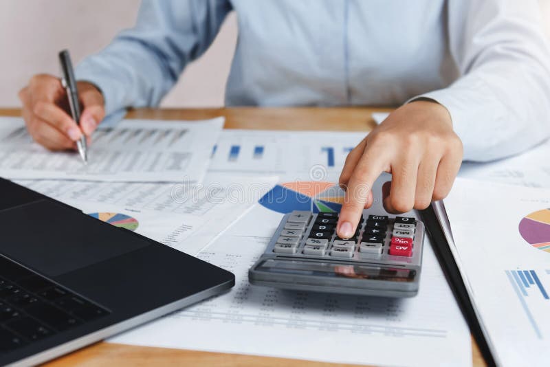 el contable que usa la calculadora con la pluma en el escritorio para calcula finan