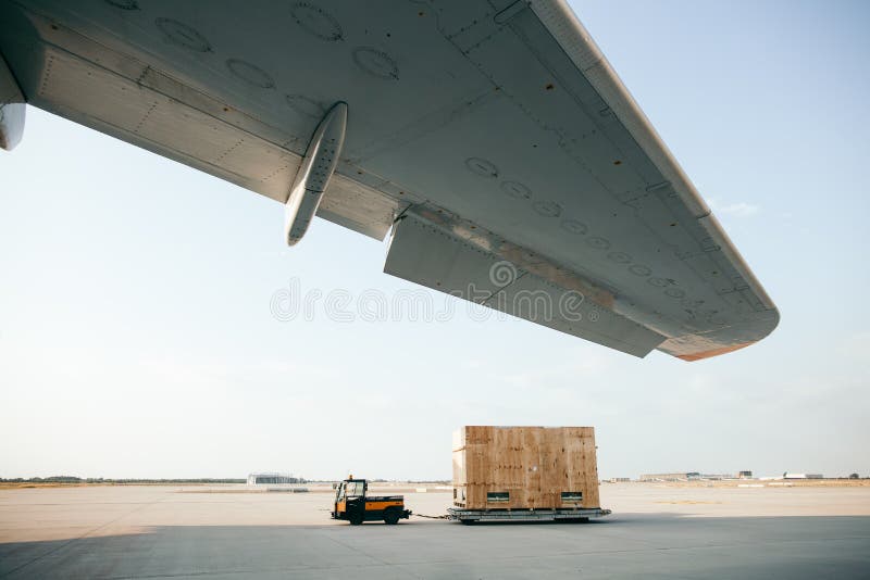 El contenedor para mercancías se está llevando al aeroplano imagen de archivo libre de regalías El contenedor para mercancías se está llevando al aeroplano imagen de archivo libre de regalías
