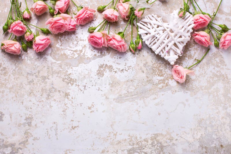 El corazón y las rosas rosadas florece en fondo texturizado vintage gris foto de archivo libre de regalías El corazón y las rosas rosadas florece en fondo texturizado vintage gris foto de archivo libre de regalías