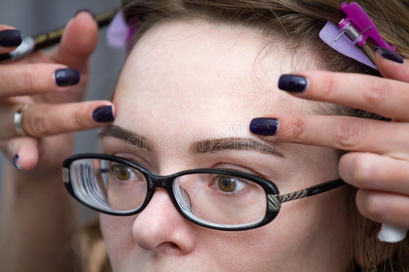 El Cosmetologist que aplica permanente compone (tatuaje) en las cejas fotos de archivo libres de regalías El Cosmetologist que aplica permanente compone (tatuaje) en las cejas fotos de archivo libres de regalías