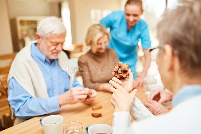 El cuidador cuida para los mayores en terapia de la demencia imagen de archivo libre de regalías El cuidador cuida para los mayores en terapia de la demencia imagen de archivo libre de regalías