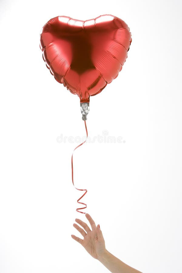El dejar de la mano va del globo en forma de corazón imagenes de archivo El dejar de la mano va del globo en forma de corazón imagenes de archivo