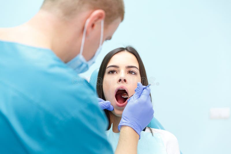 El dentista examina los dientes de una chica joven en su recepción fotografía de archivo libre de regalías El dentista examina los dientes de una chica joven en su recepción fotografía de archivo libre de regalías