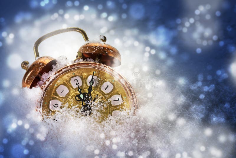 Vintage alarm clock in the snow shows 2017, concept for new year, blue bokeh lights background with copy space. Vintage alarm clock in the snow shows 2017, concept for new year, blue bokeh lights background with copy space