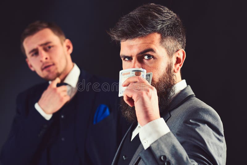 El dinero no tiene ningún olor Hombre barbudo con el dinero del efectivo Compañeros de trabajo o colegas acertados Los socios com imagenes de archivo El dinero no tiene ningún olor Hombre barbudo con el dinero del efectivo Compañeros de trabajo o colegas acertados Los socios com imagenes de archivo