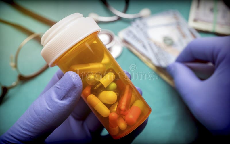El doctor apoya el barco con las cápsulas de diverso tamaño junto con algunos boletos del dólar americano foto de archivo El doctor apoya el barco con las cápsulas de diverso tamaño junto con algunos boletos del dólar americano foto de archivo