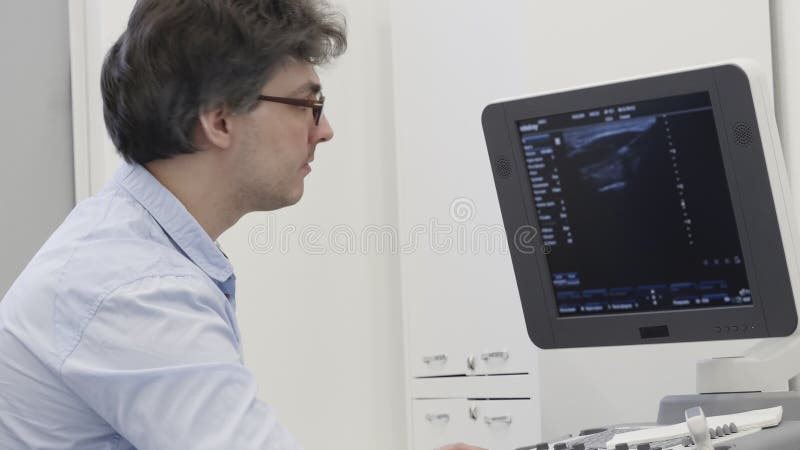 El doctor de la sonografía detecta la enfermedad en el ultrasonido para examinar