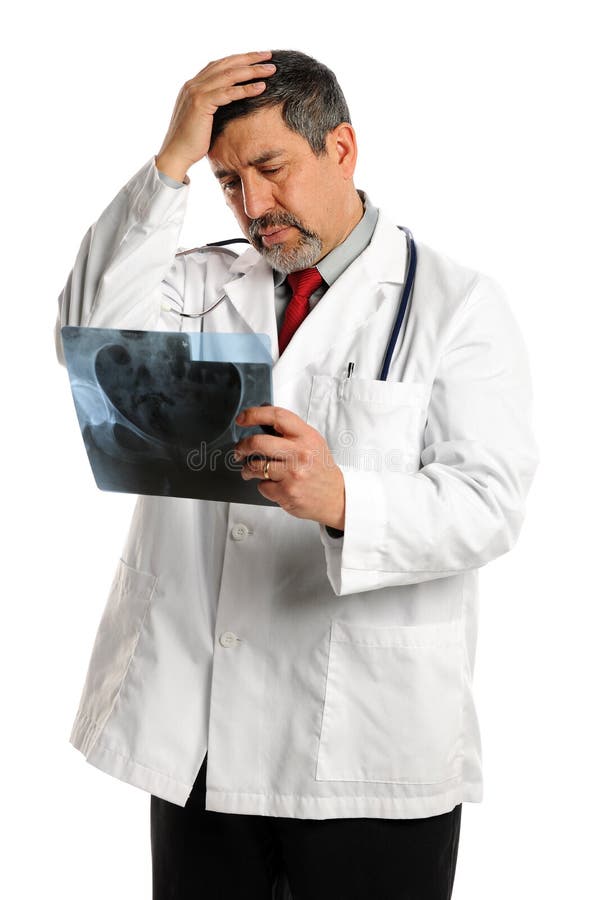El doctor de sexo masculino hispánico Looking en la radiografía fotos de archivo libres de regalías
