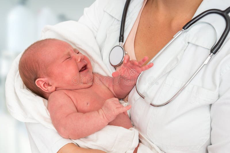 Pediatrician doctor with stethoscope is holding newborn baby in arms. Pediatrician doctor with stethoscope is holding newborn baby in arms