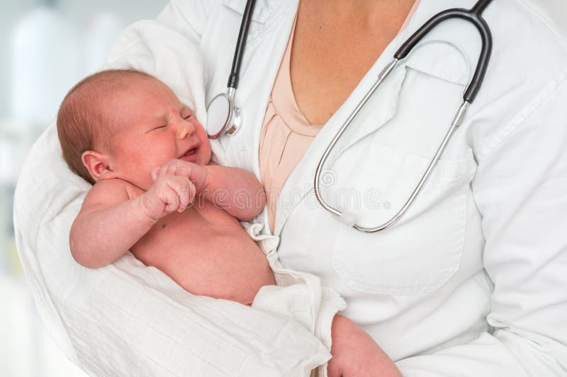 Pediatrician doctor with stethoscope is holding newborn baby in arms. Pediatrician doctor with stethoscope is holding newborn baby in arms