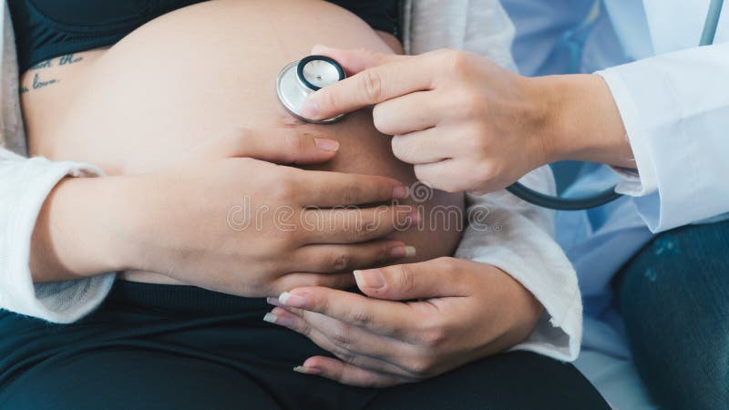 El doctor está diagnosticando a mujeres embarazadas fotografía de archivo libre de regalías El doctor está diagnosticando a mujeres embarazadas fotografía de archivo libre de regalías