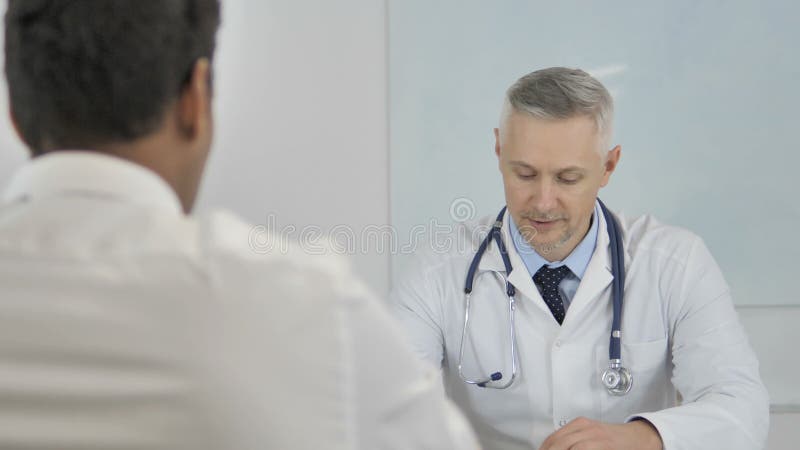 El doctor mayor Advising Patient, ayudando con los problemas de salud
