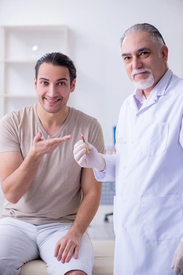 El doctor paciente de sexo masculino del visitng para la inoculación tirada fotos de archivo libres de regalías El doctor paciente de sexo masculino del visitng para la inoculación tirada fotos de archivo libres de regalías
