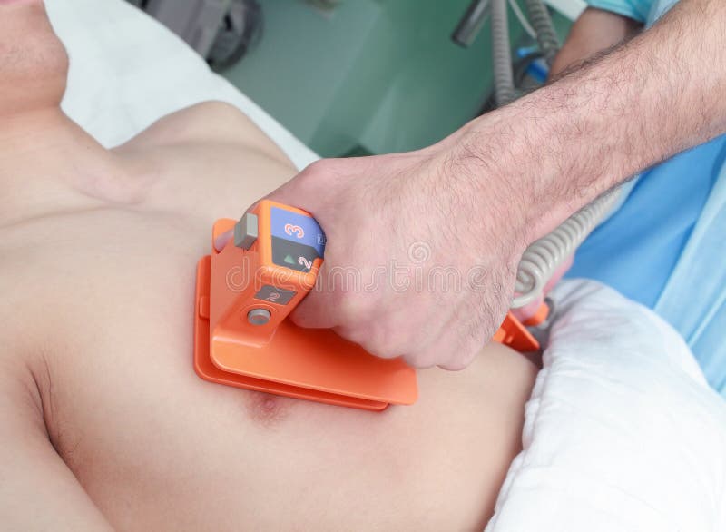 El doctor reanima al paciente por un defibrillator eléctrico