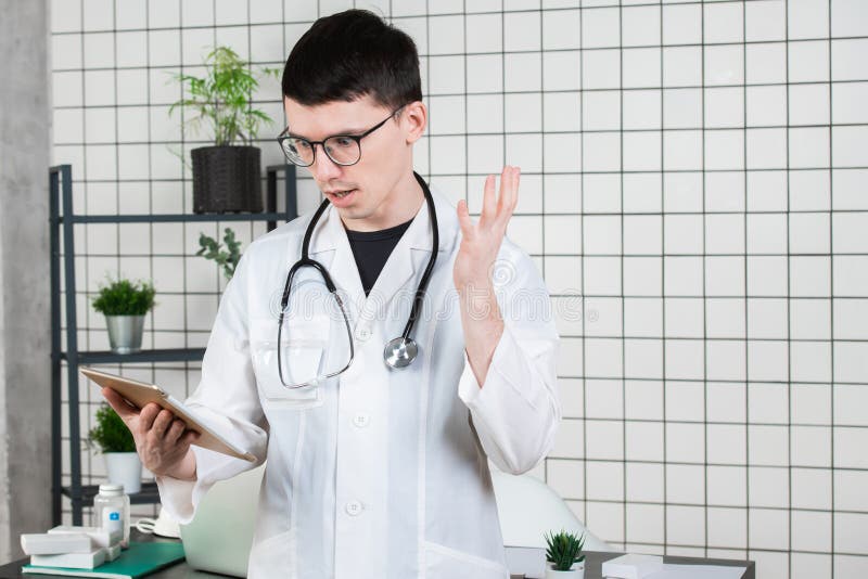El doctor sorprendió, chocado de notas sobre la tableta fotos de archivo libres de regalías El doctor sorprendió, chocado de notas sobre la tableta fotos de archivo libres de regalías