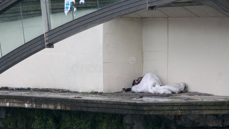 El dormir de la persona sin hogar áspero debajo del puente en Dublín, Irlanda imagen de archivo El dormir de la persona sin hogar áspero debajo del puente en Dublín, Irlanda imagen de archivo