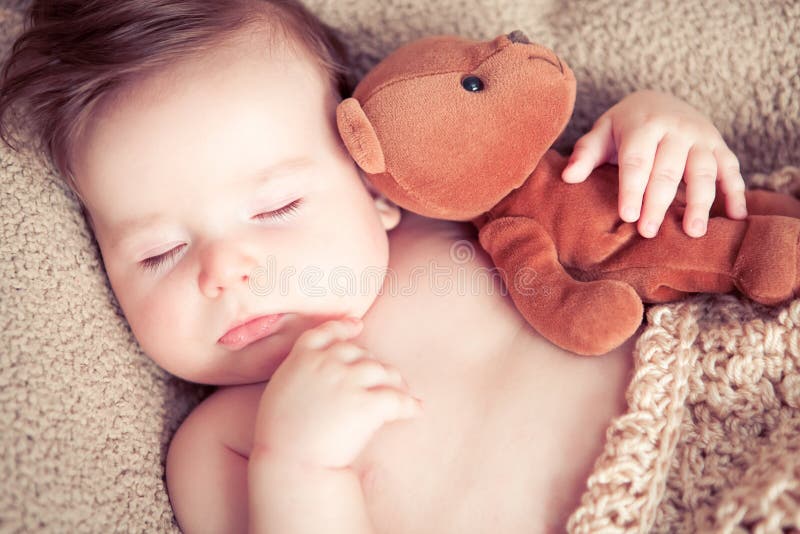 El dormir recién nacido con un juguete foto de archivo libre de regalías El dormir recién nacido con un juguete foto de archivo libre de regalías