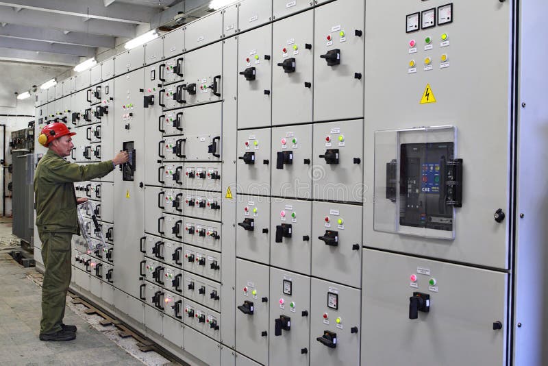 El electricista del ingeniero cambia el equipo del dispositivo de distribución foto de archivo libre de regalías El electricista del ingeniero cambia el equipo del dispositivo de distribución foto de archivo libre de regalías