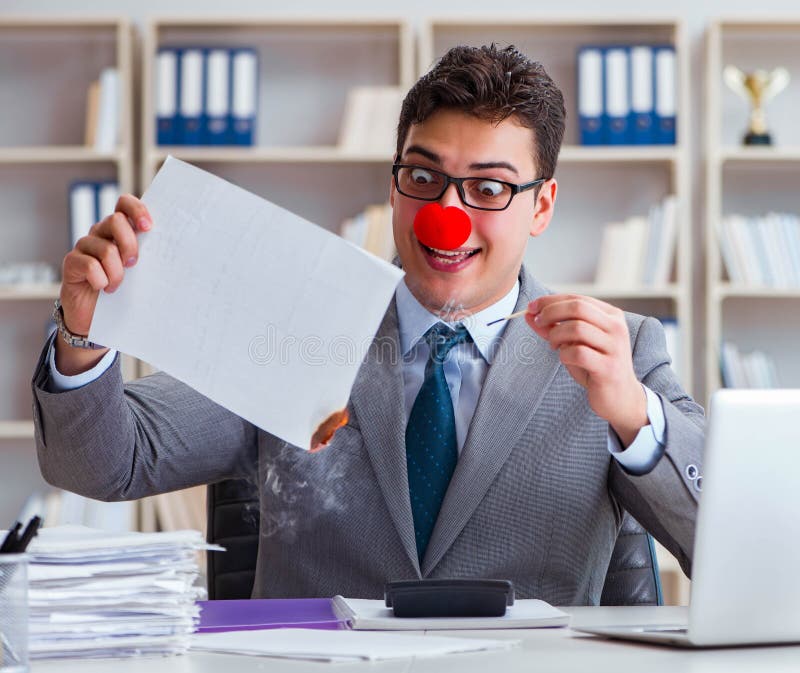 El empresario payaso quemando papeles en la oficina fotografía de archivo libre de regalías