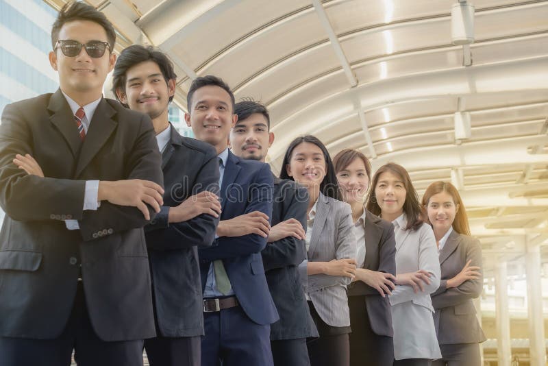El equipo asiático joven del negocio se coloca con confianza y orgullo imágenes de archivo libres de regalías El equipo asiático joven del negocio se coloca con confianza y orgullo imágenes de archivo libres de regalías