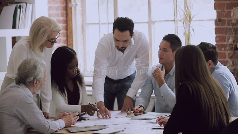 El equipo de negocios genera ideas para resolver errores en el papeleo en la reunión almacen de metraje de vídeo
